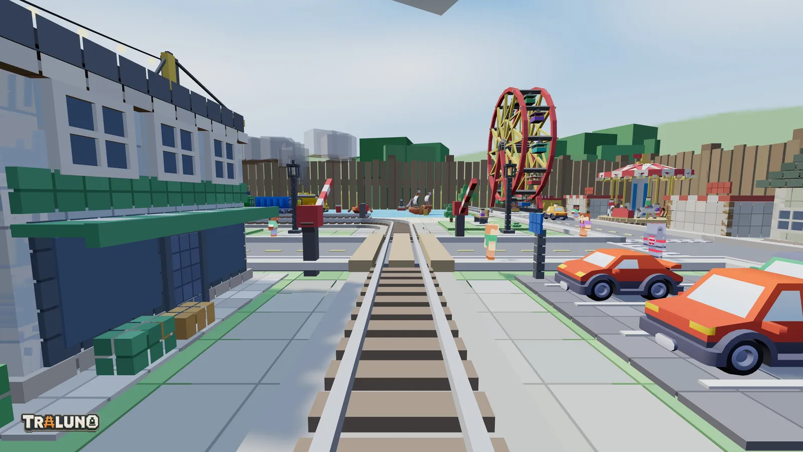 The view from the front of the Steam Express, running along the main line towards a level crossing, with a ferris wheel and a carousel beyond and the garden fence behind the table.