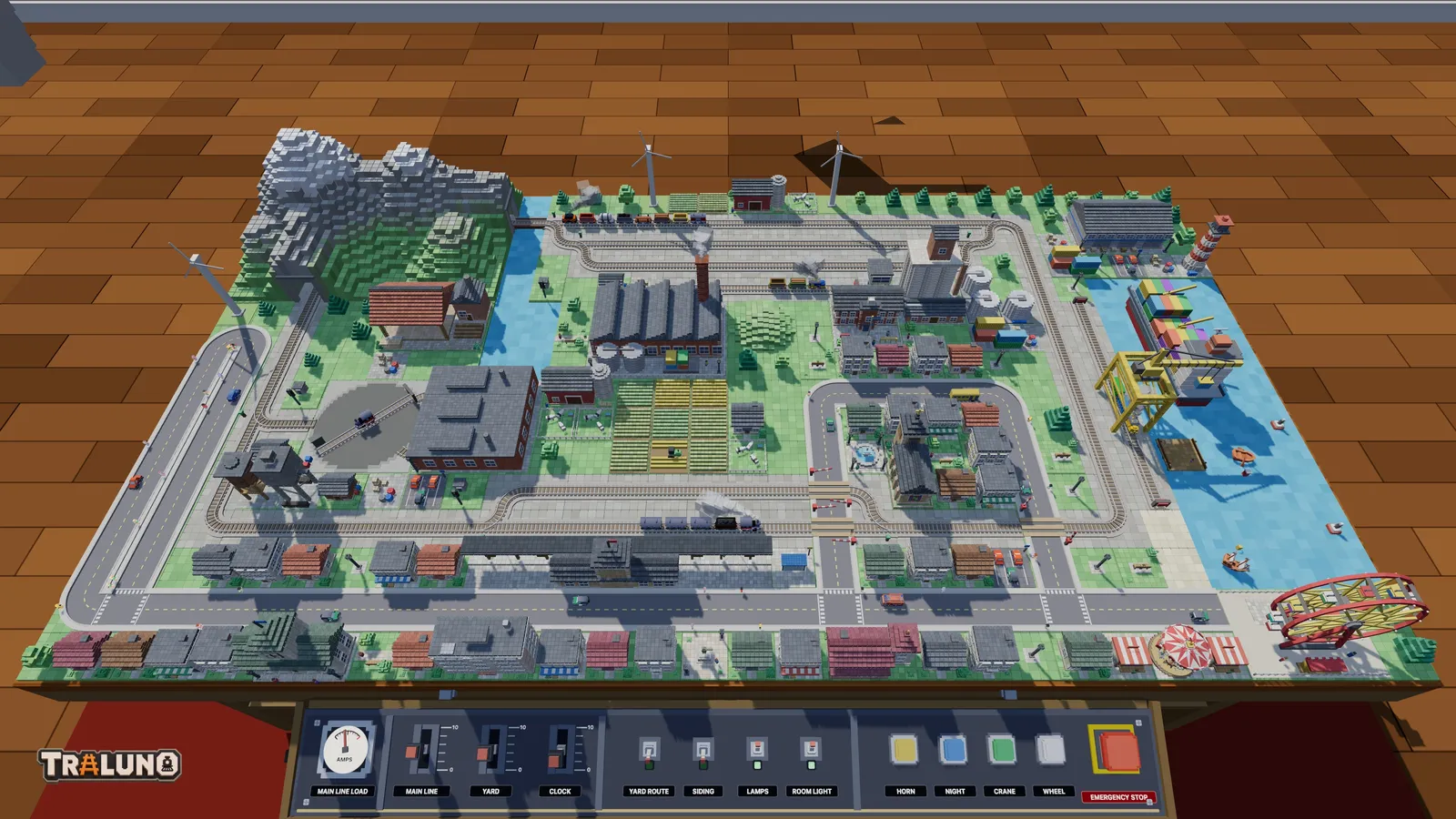 The demo layout on a single table, seen from above the front edge: track, a town, industry, a harbour and a mountain, with the control desk below.