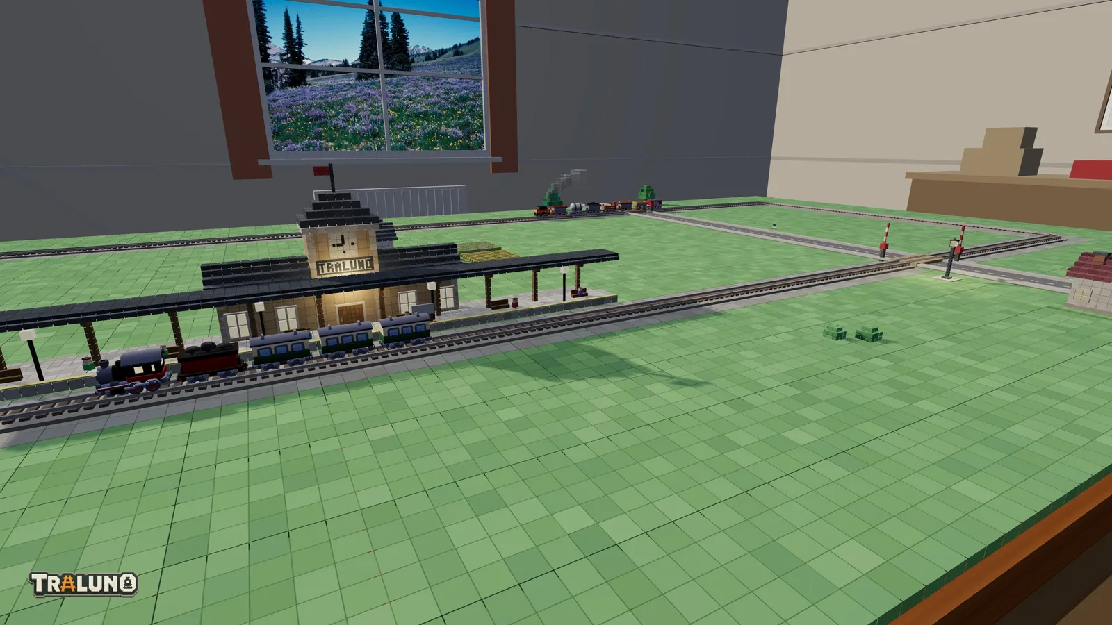An oval of track on one table with a station on the front straight, the Steam Express at its platform, a street crossing the line with level crossing gates, and a freight train on the back straight.