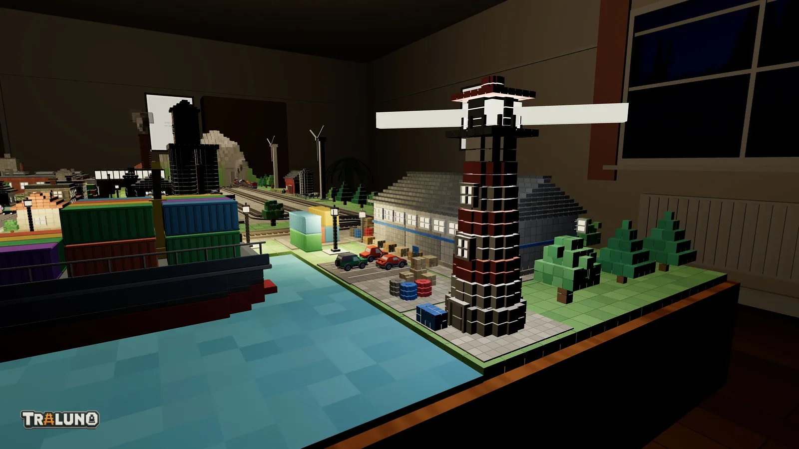 The Lighthouse at night on the harbour's edge: a striped tower with its lantern glazing and two small windows lit, and a two-armed beam standing out either side of the lantern, with the cargo ship's containers on the left and the goods warehouse behind.