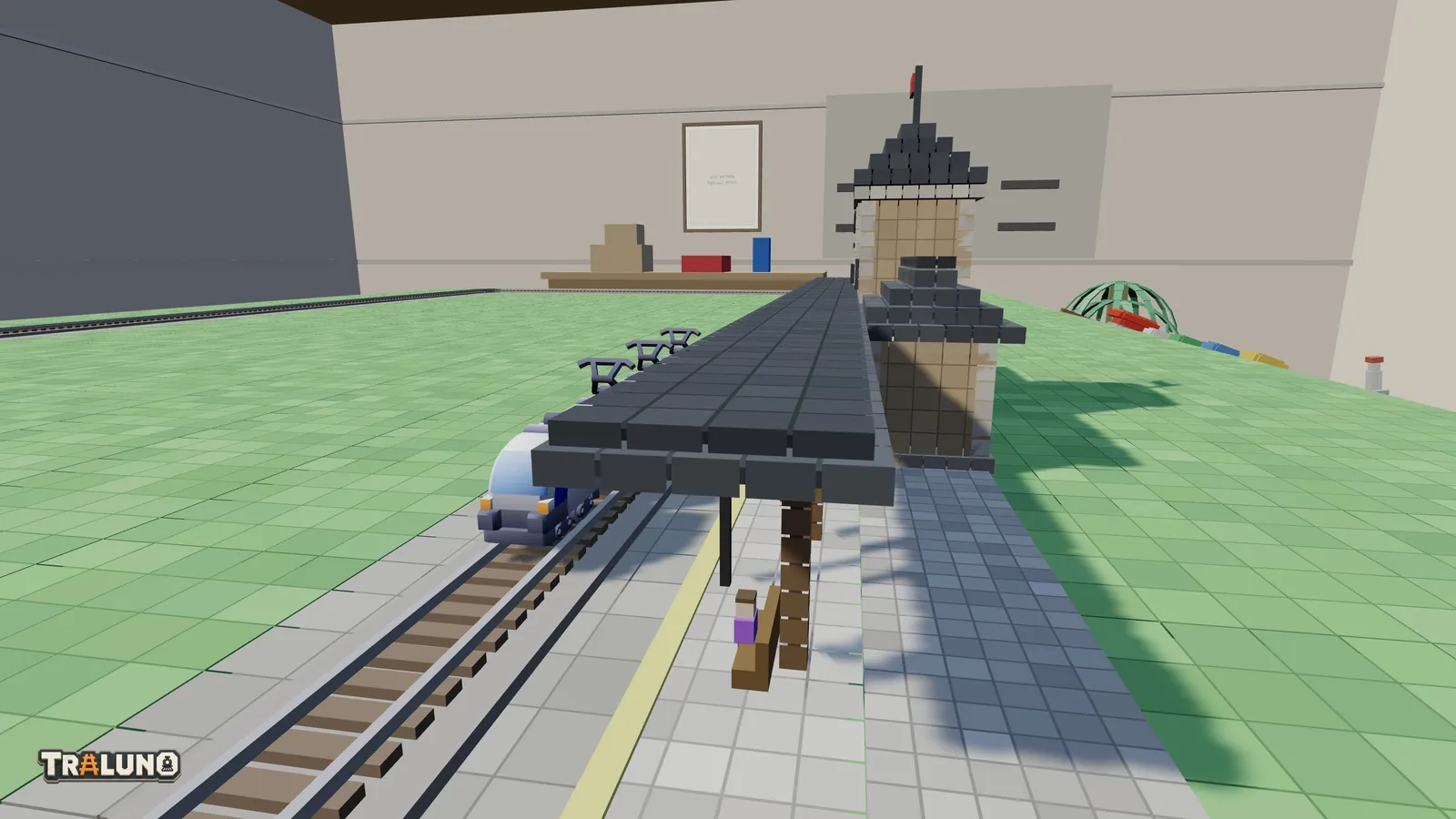 The Silver Streamliner at a station, seen from the end of the platform, with the canopy roof stopping at the platform edge beside the train.