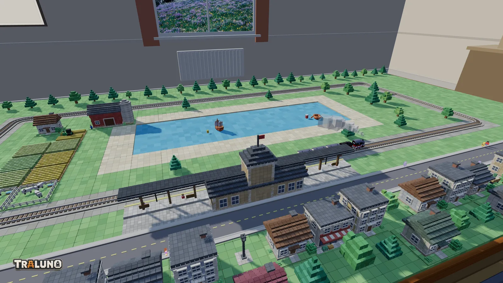 A small Traluno layout laid on a bare table through the place_item tool: an oval of track around a lake with two boats, a station on the front straight with a steam train by it, a street and a row of houses in front, farmland on the left and rows of trees behind.