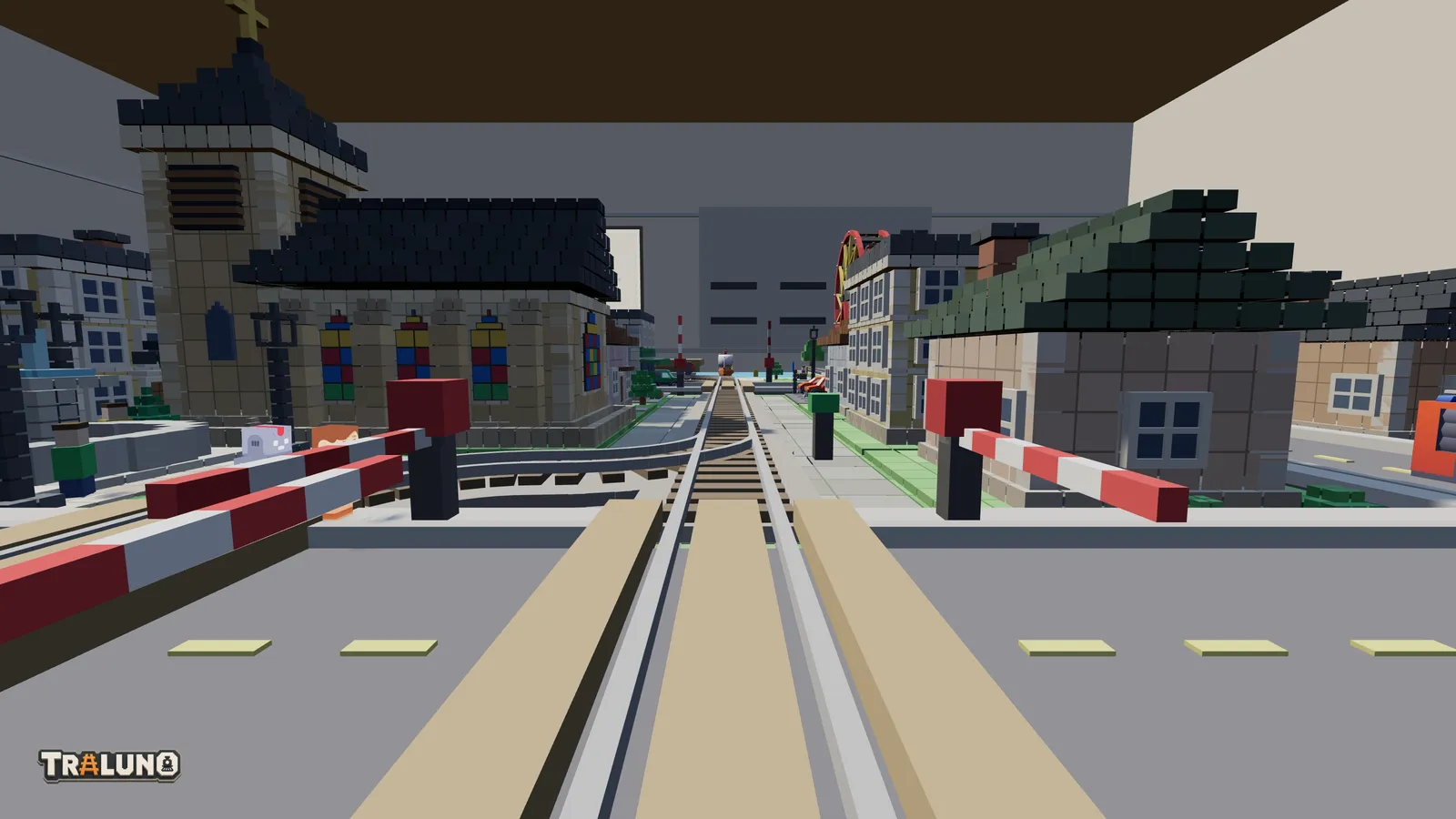 The view from the front of a train as it crosses a street at a level crossing, the red and white booms down on both sides, a church with stained glass windows on the left and houses on the right.
